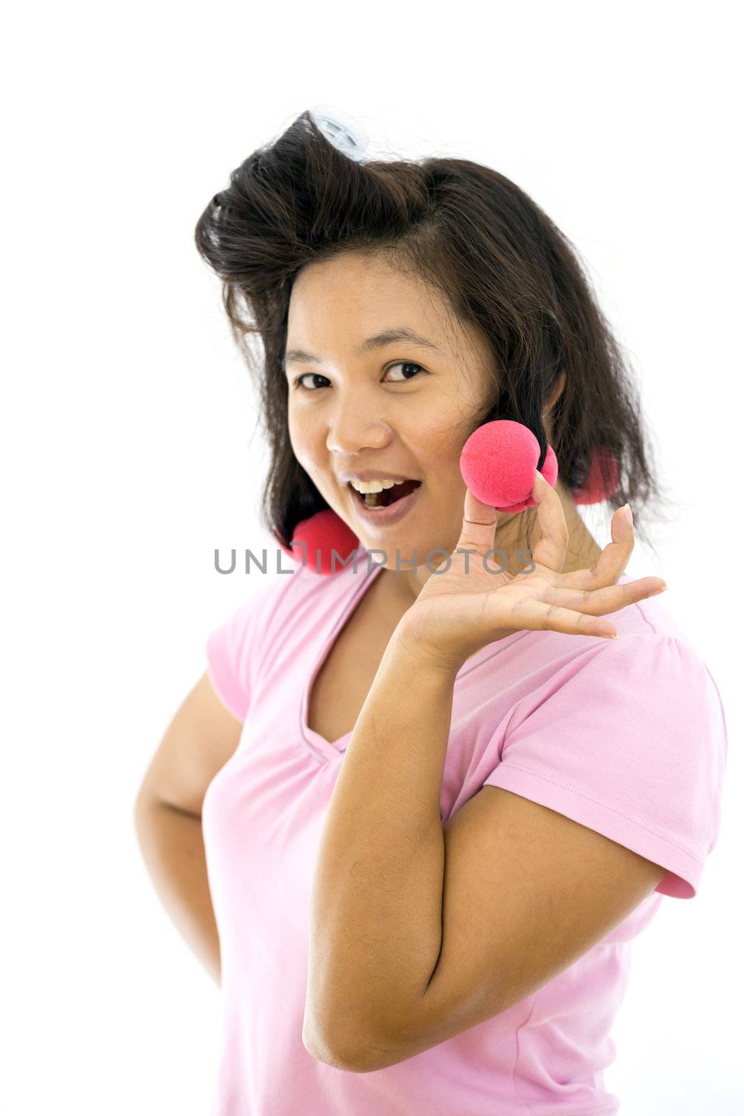 pretty young adult woman with hair curlers on white background (selective focus at hair curler)