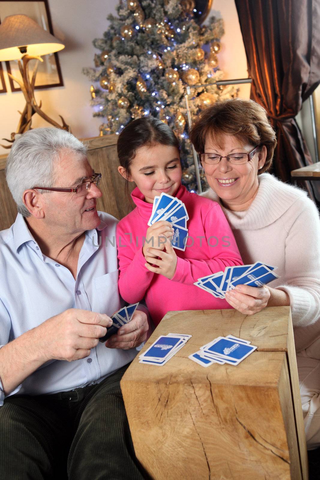 Family playing card game at Christmas by phovoir