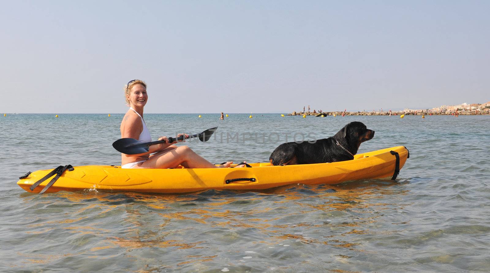 woman and dog on a kayak by cynoclub