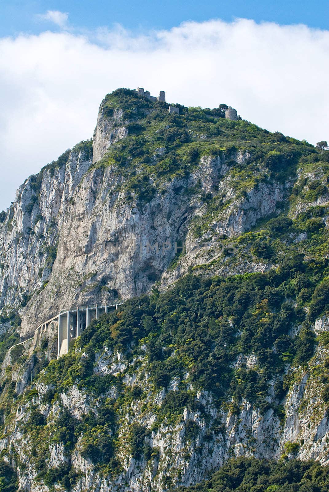 rugged cliffs falling into mediteranean with buildings on top