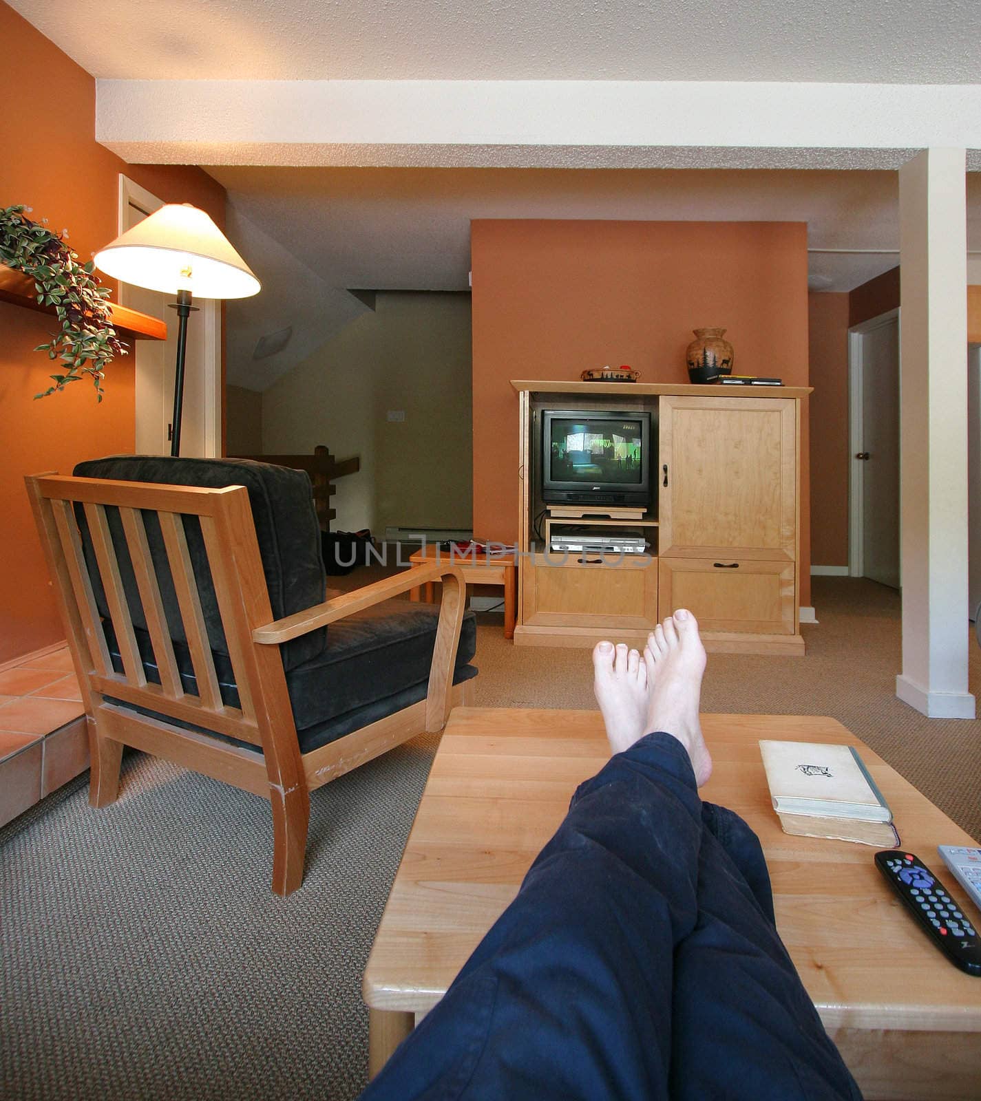 Feet up on the table relaxing and watching TV