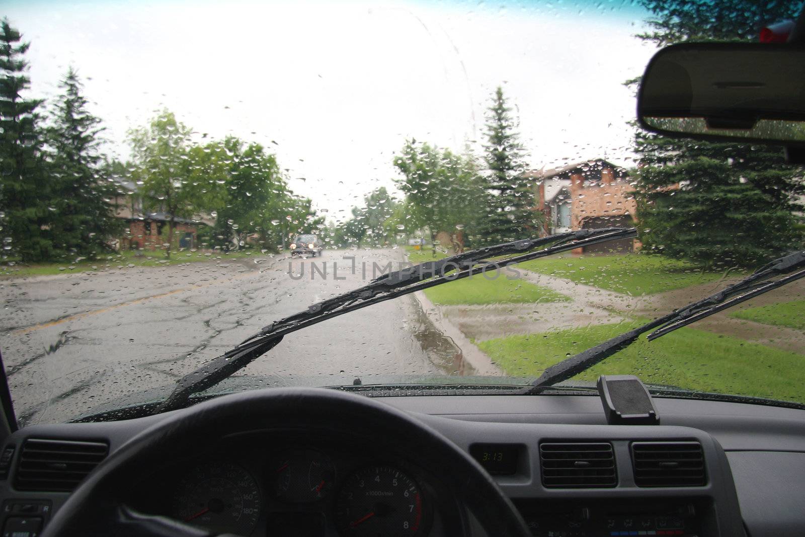 View from the drivers seat inside a car on a rainy day