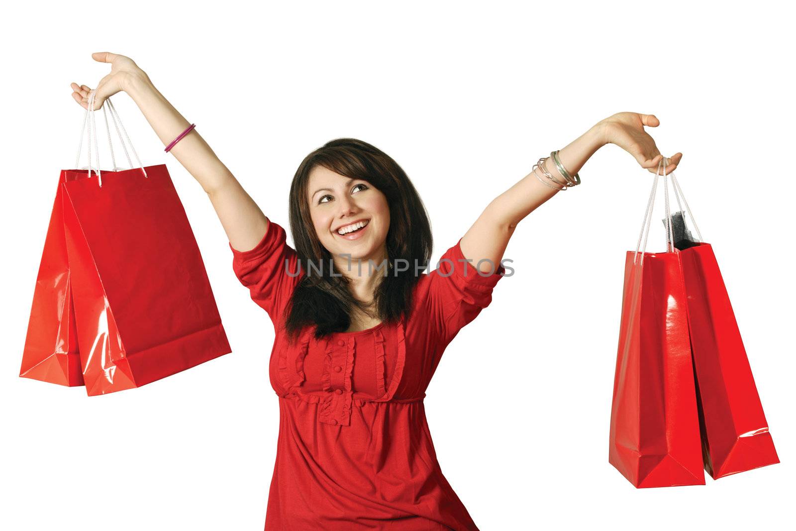 A beautiful young female holding shopping bags with a huge grin on her face.
