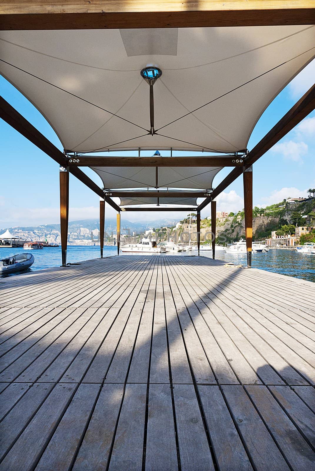 boats at end of wooden pier sorrento italy