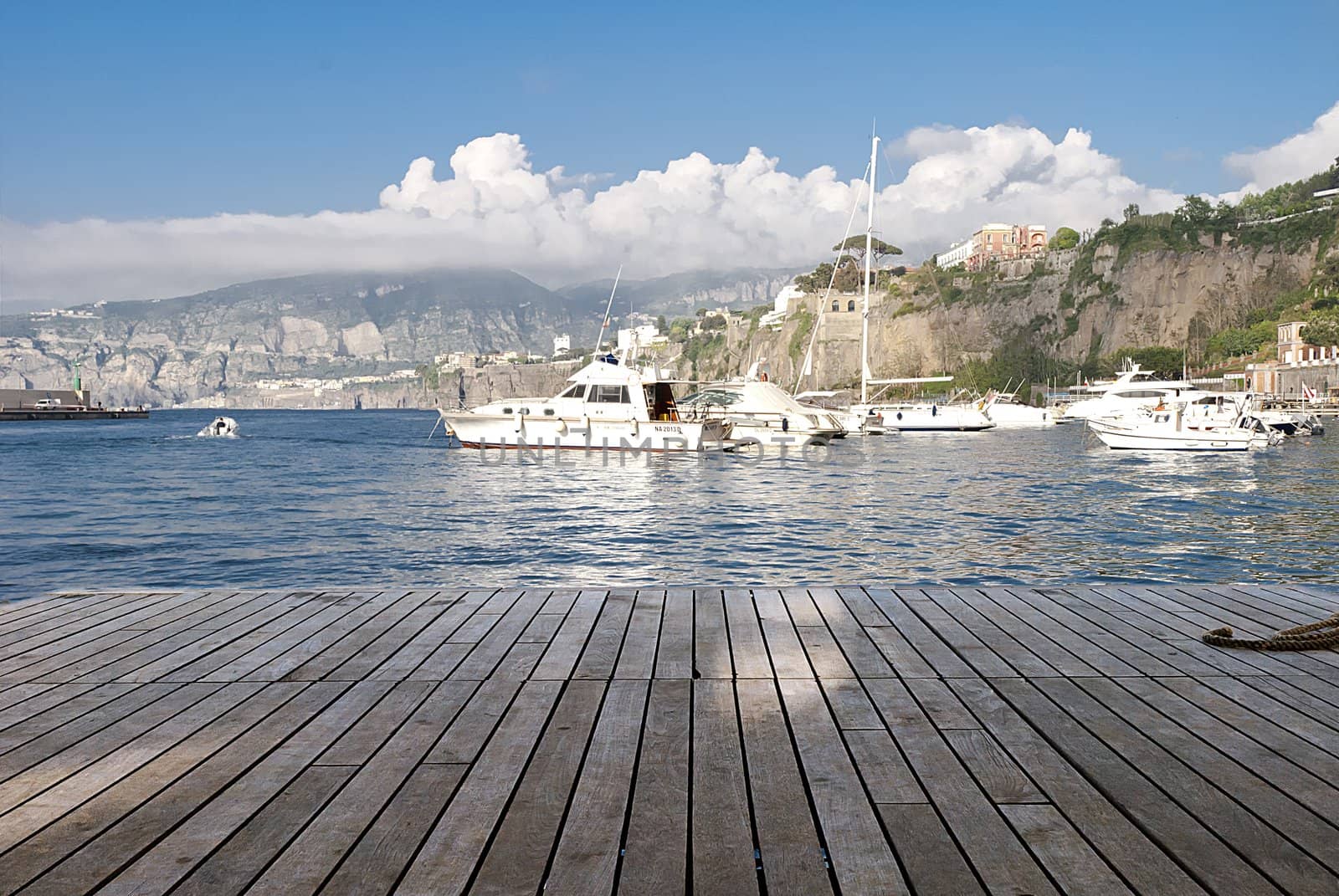 boats at end of wooden pier sorrento italy by itsrich