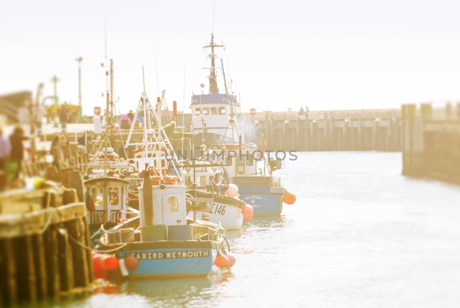 cute fishing boats in harbour, west bay, dorset england vintage colour effects