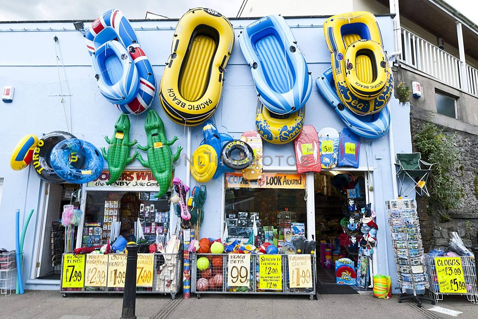 inflatable sea toy boats hanging on wall at sea side shop, tenby wales.
