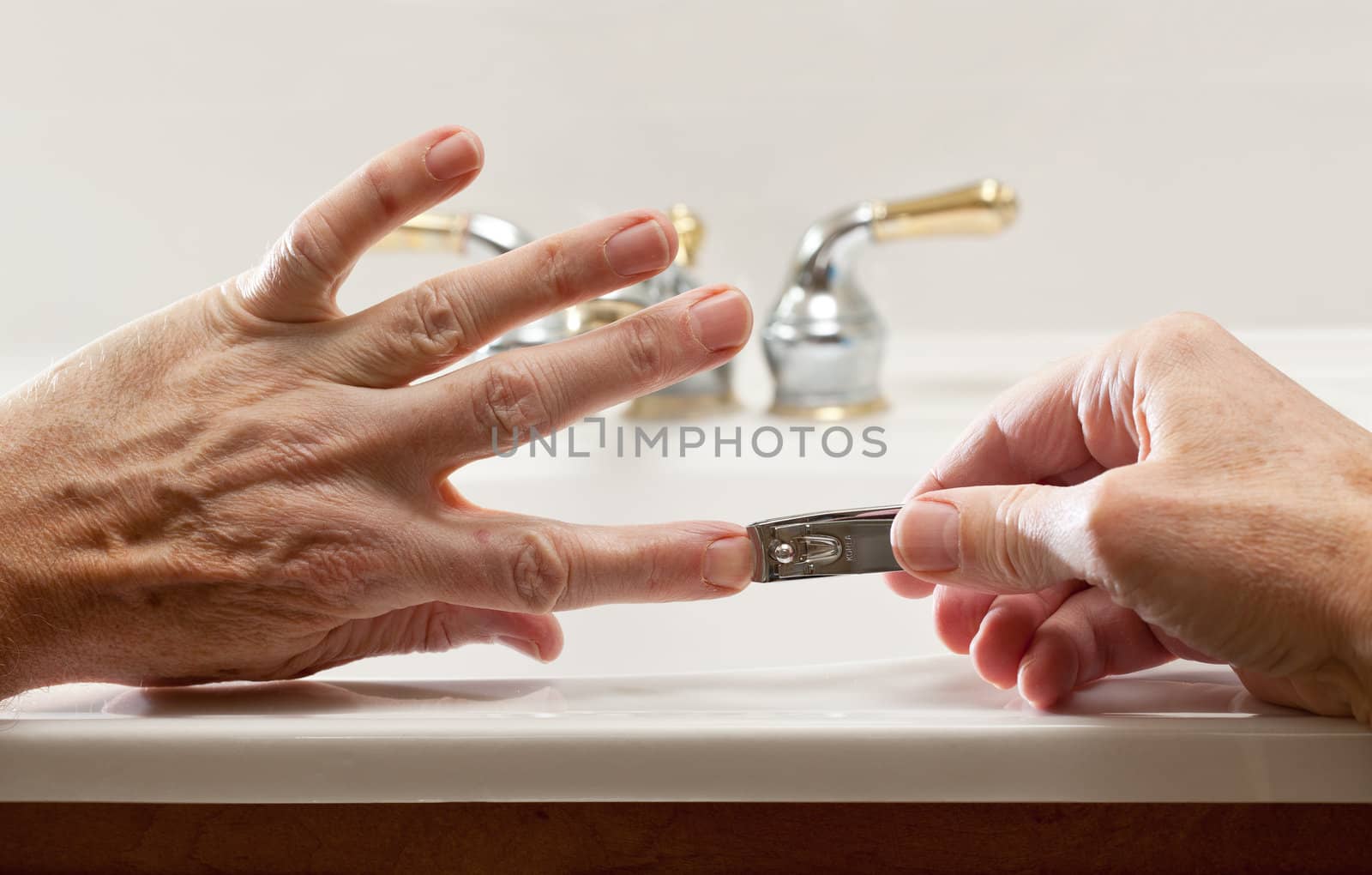 Finger nail clippings in palm of hand on bathroom sink