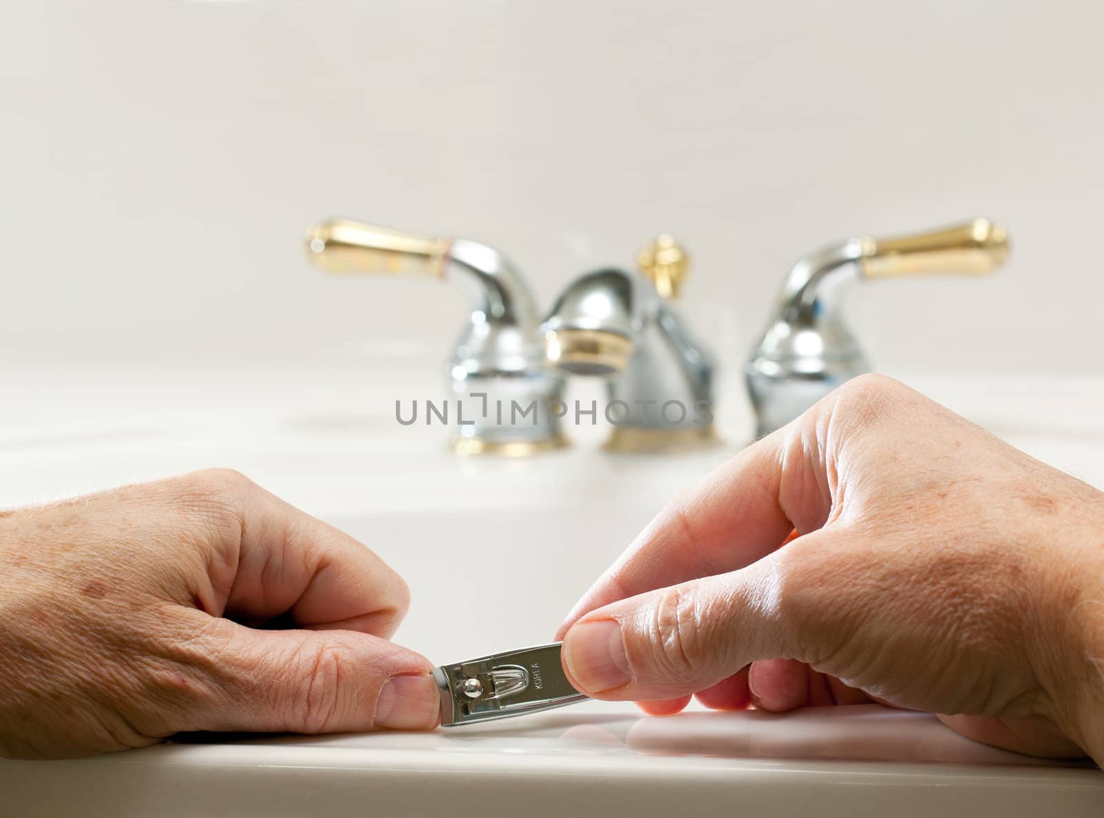 Finger nail clippings in palm of hand on bathroom sink