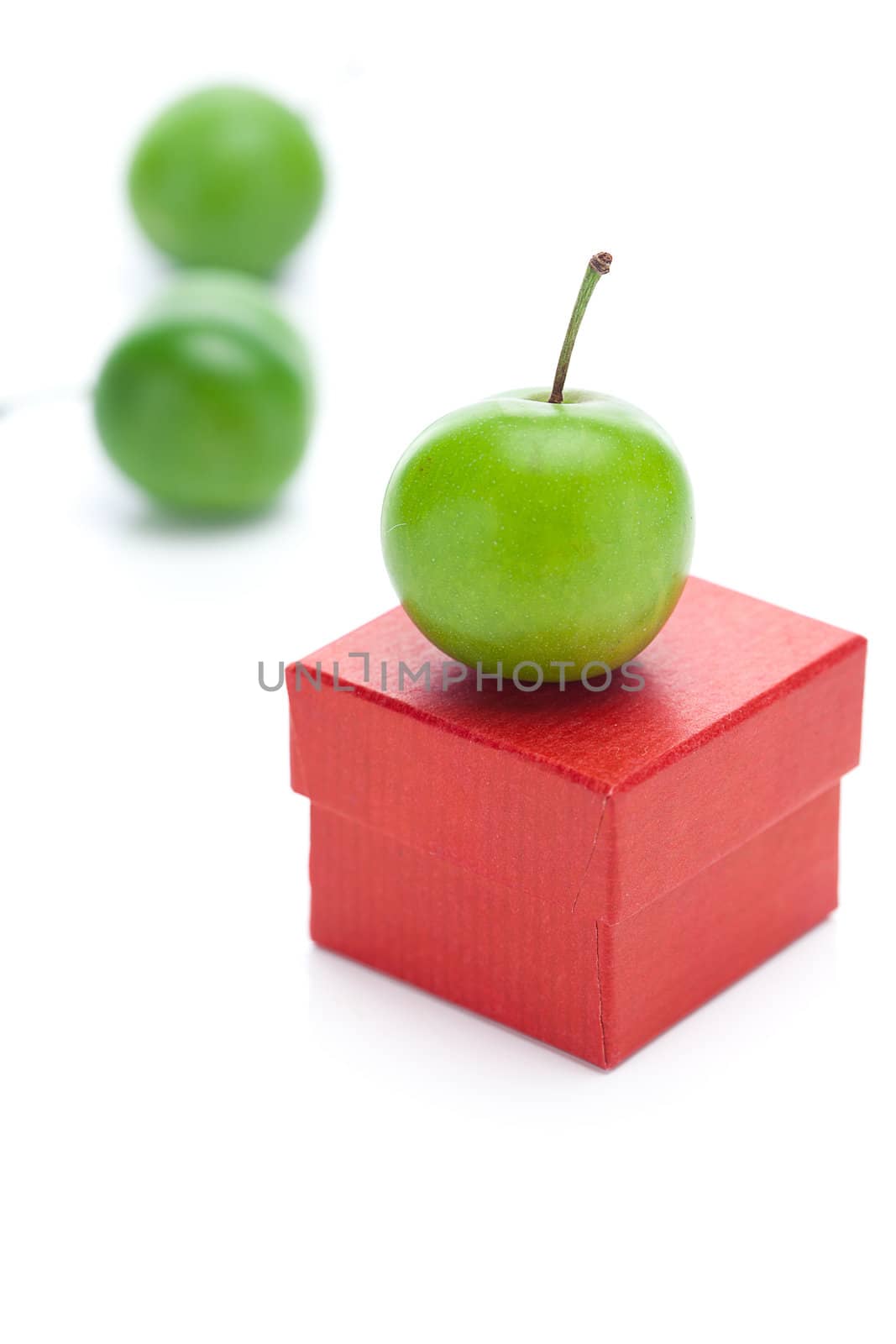 red gift box and green plum isolated on white by jannyjus