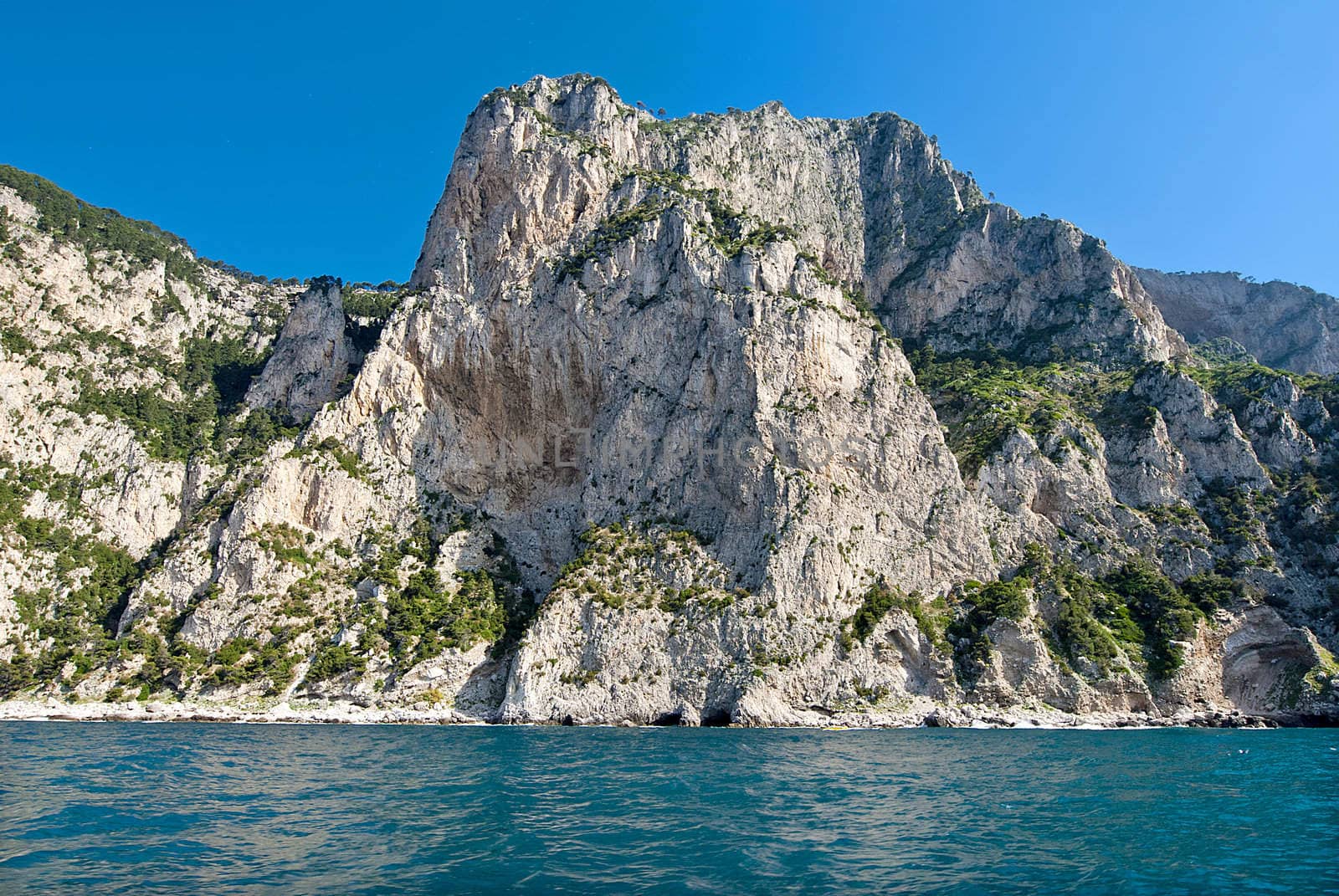 sheer cliffs of capri falling into turqoise mediterannean  sea, italy