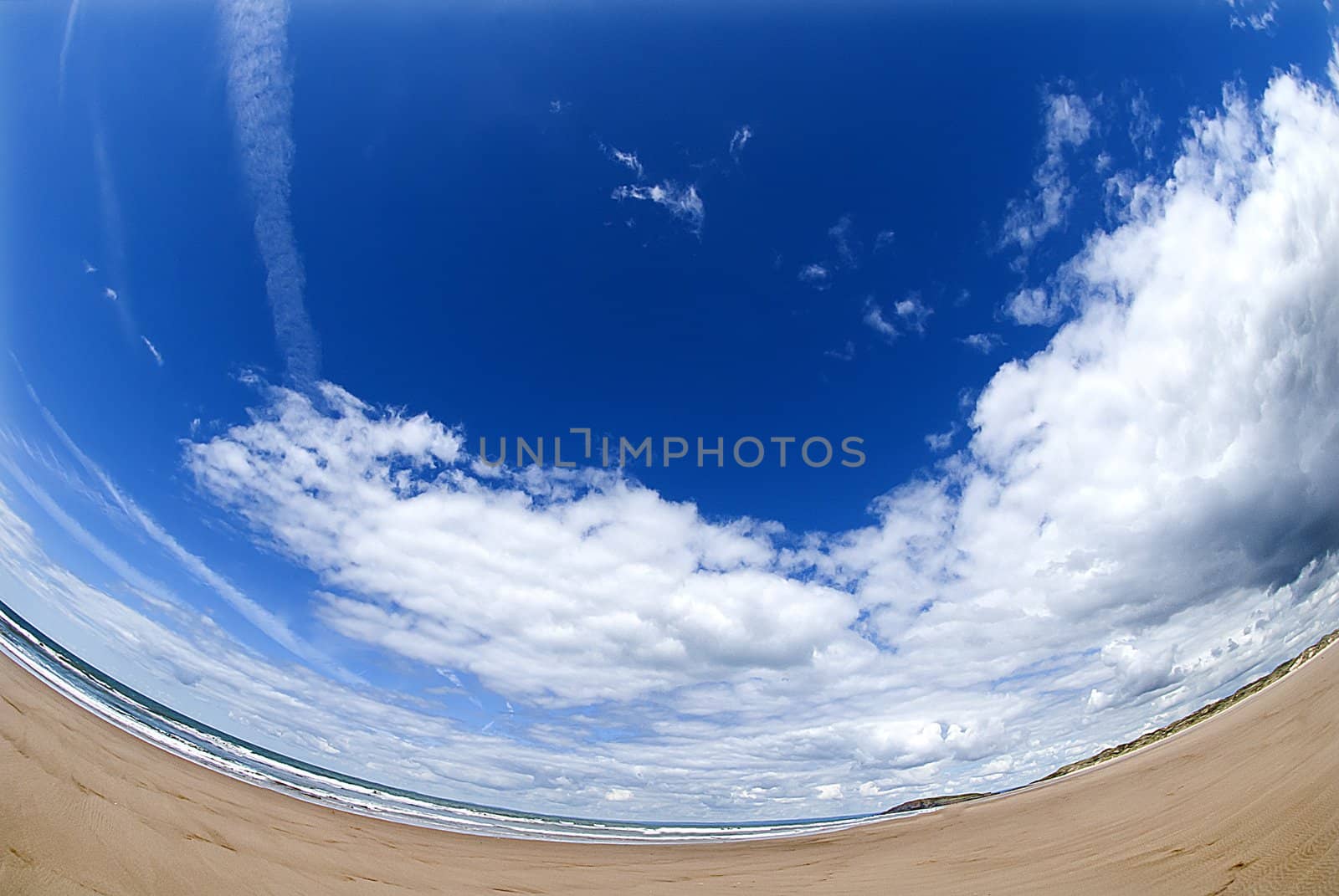 wide empty beach gower wales with blue skies and white clouds by itsrich