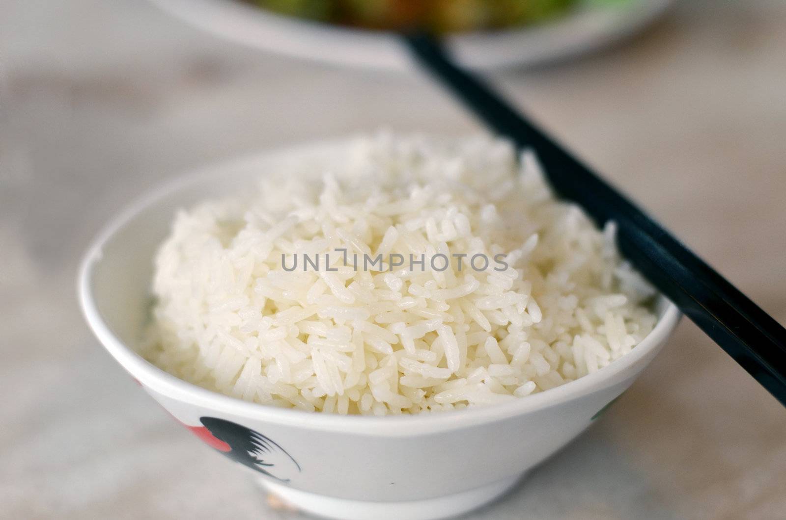 steamed rice in bowl with chopsticks