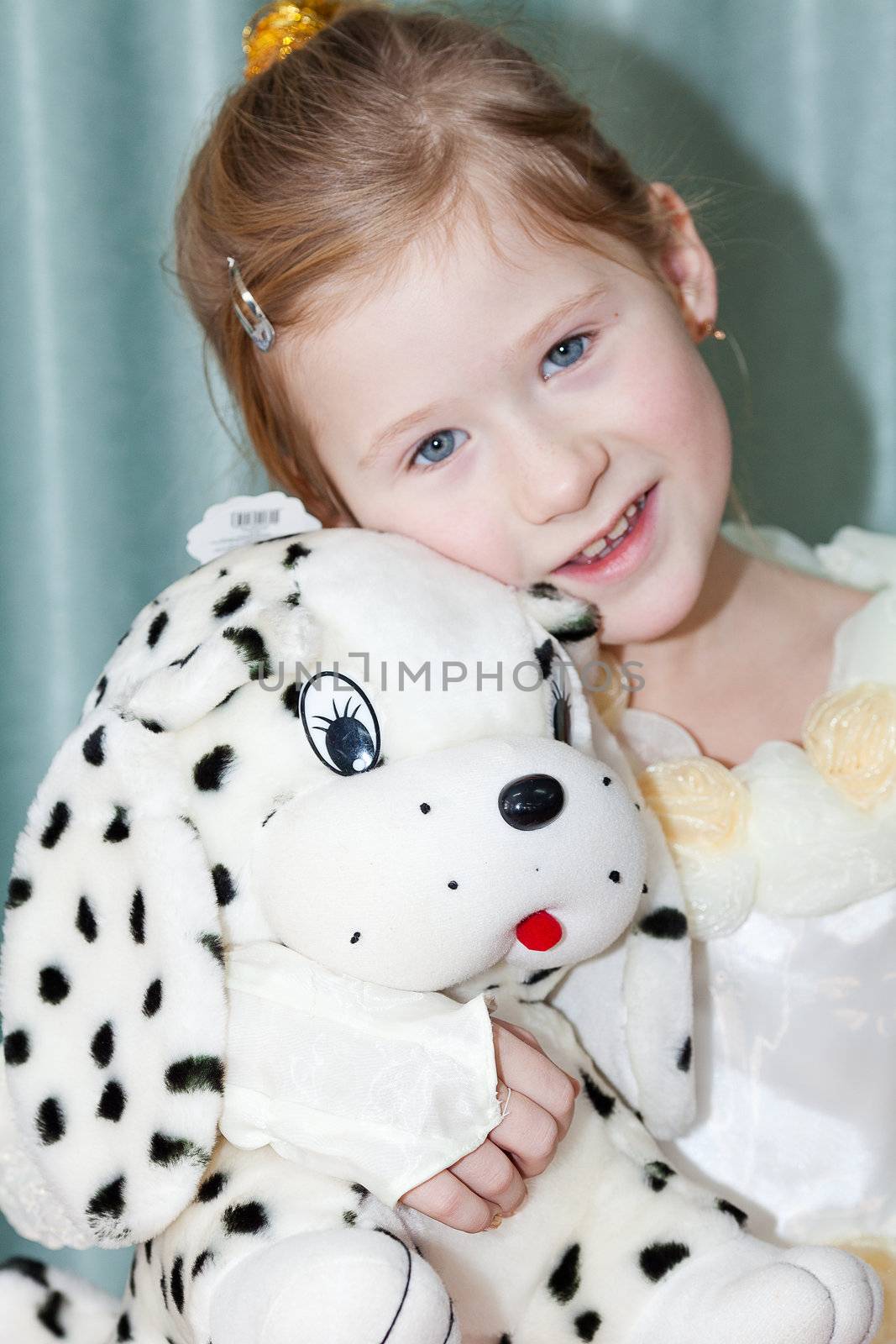 portrait of a beautiful little girl with a toy dog