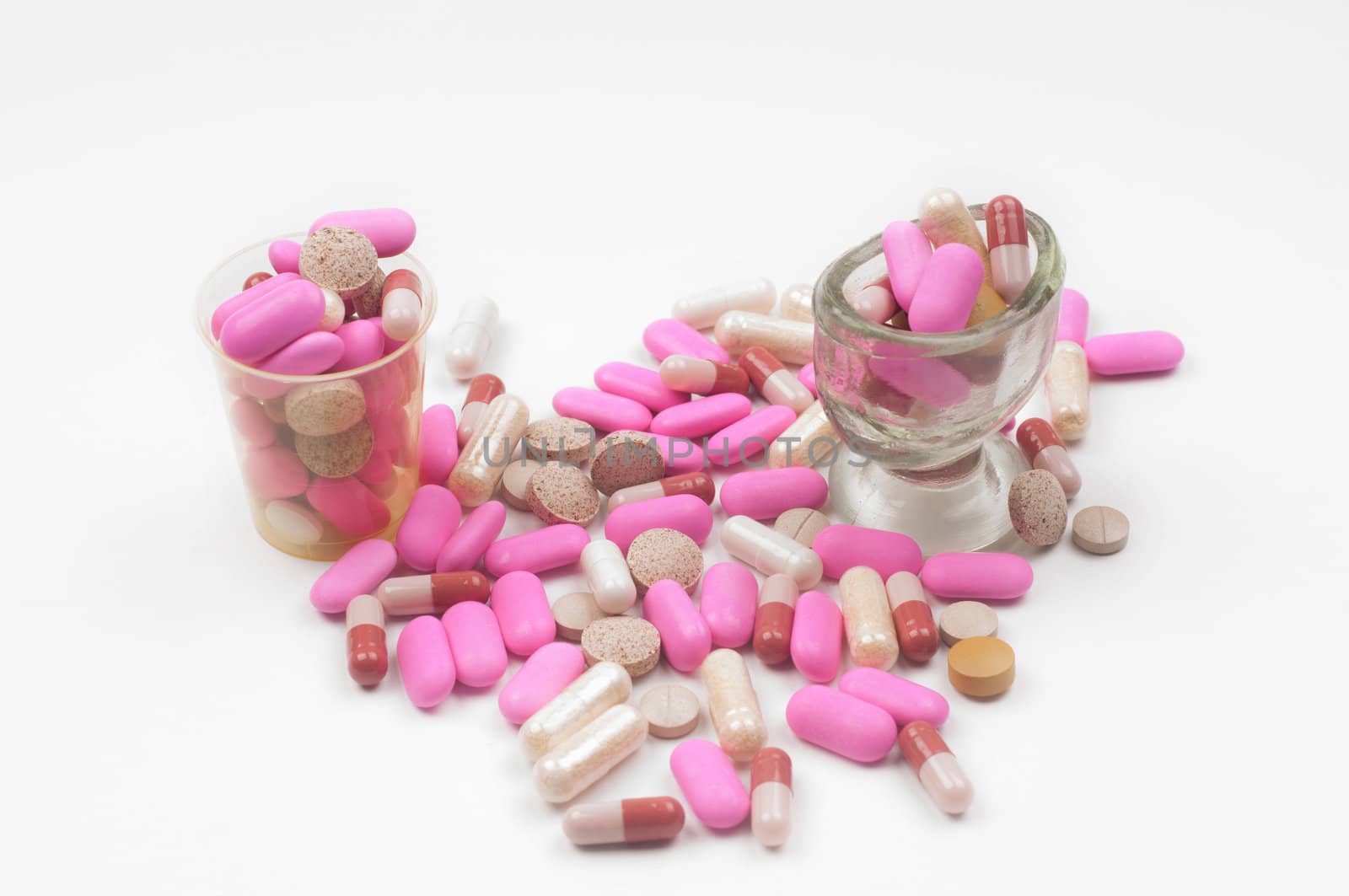 Lot of pink drugs (tablets) on light background