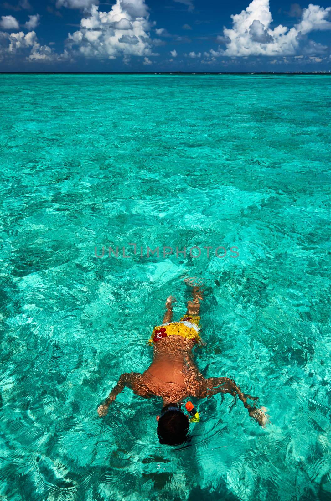 Man snorkeling in crystal clear turquoise water at tropical beach