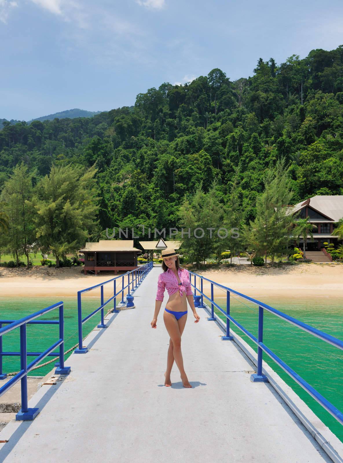 Woman at beach jetty wearing hat