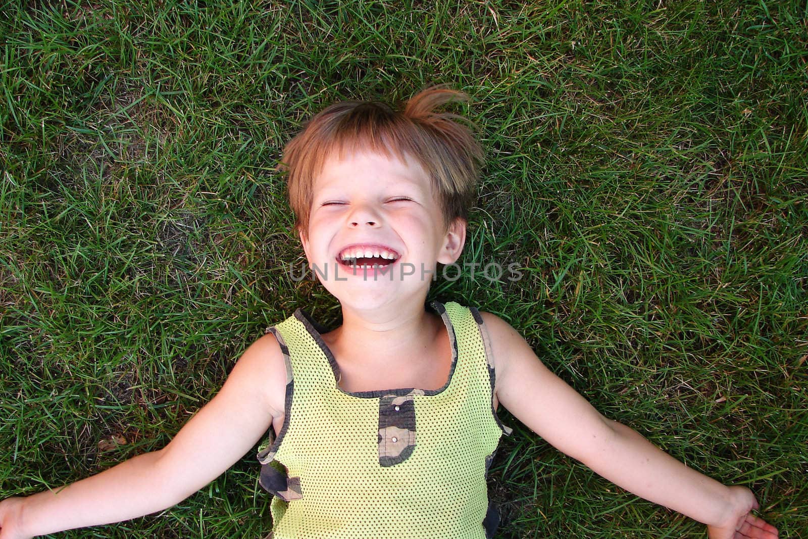 Baby laughing, lying on the grass