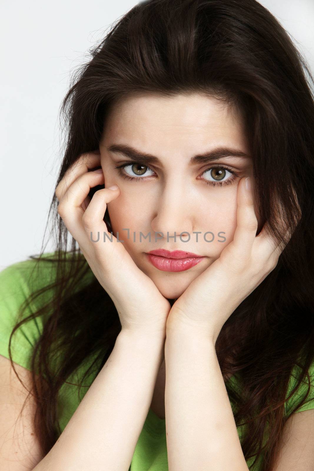Sad woman holding her cheeks with both hands
