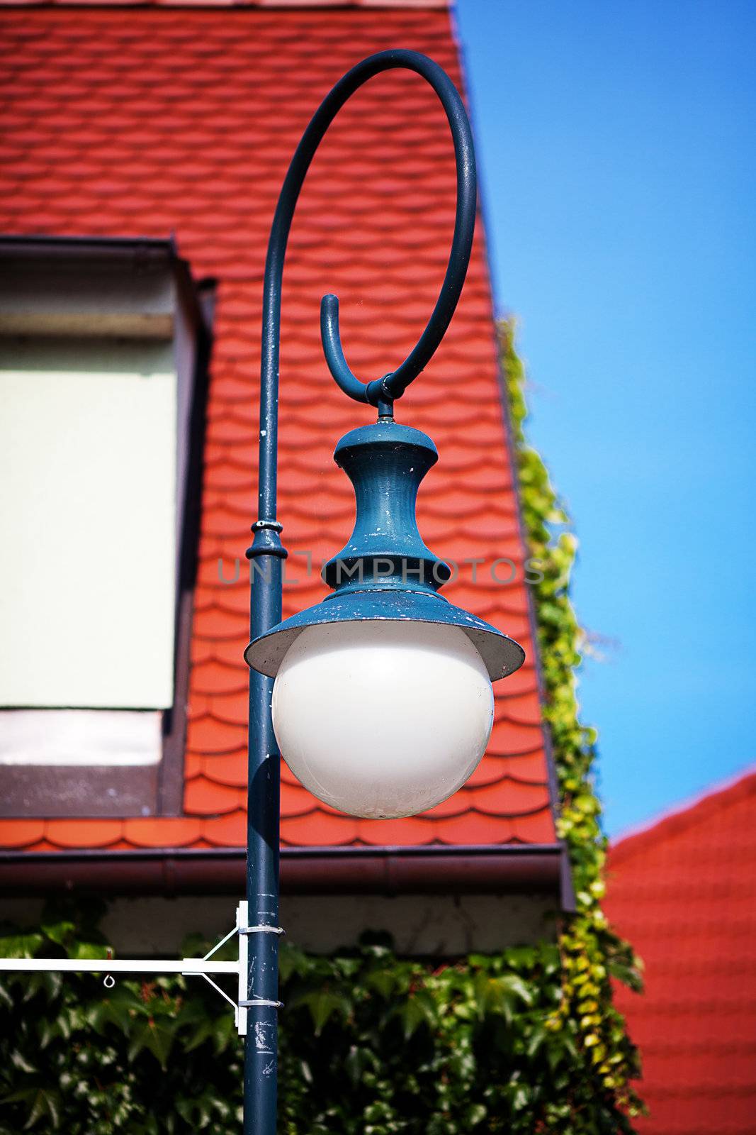 old lantern against the roof and windows by jannyjus