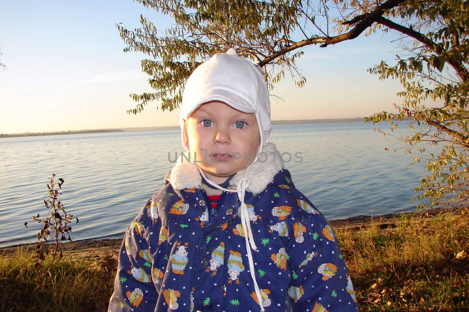 Kid on the evening walk near a river. Autumn. by NickNick