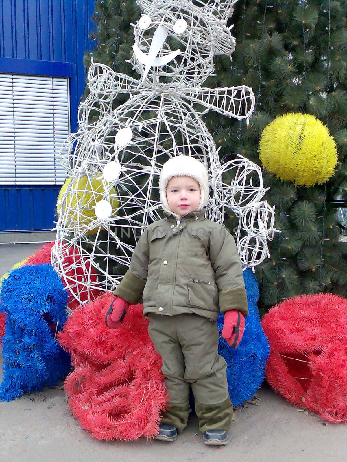 The kid next to the Christmas Tree