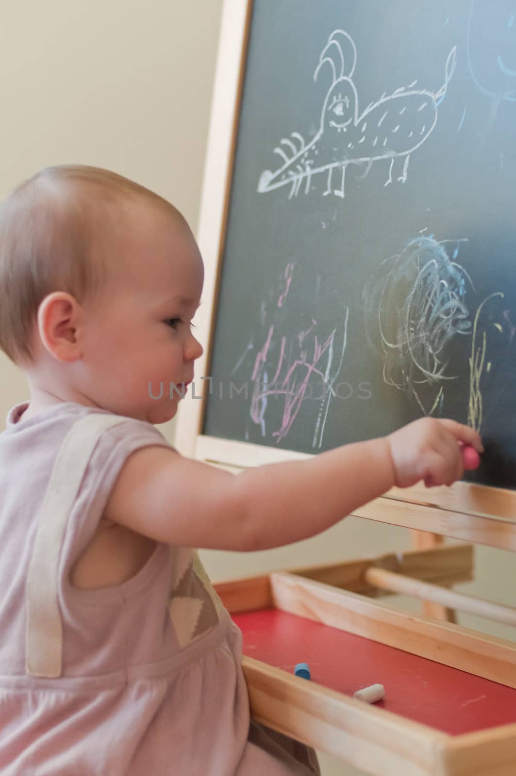 Little girl paints on the board