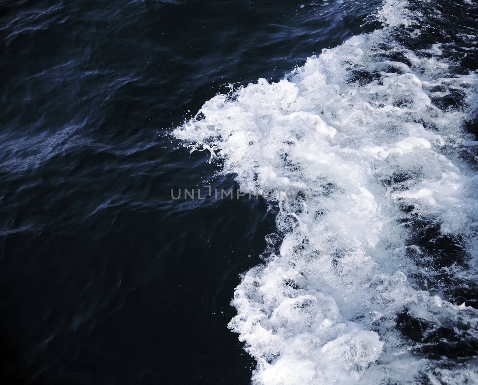 dark sea water with waves and white suds