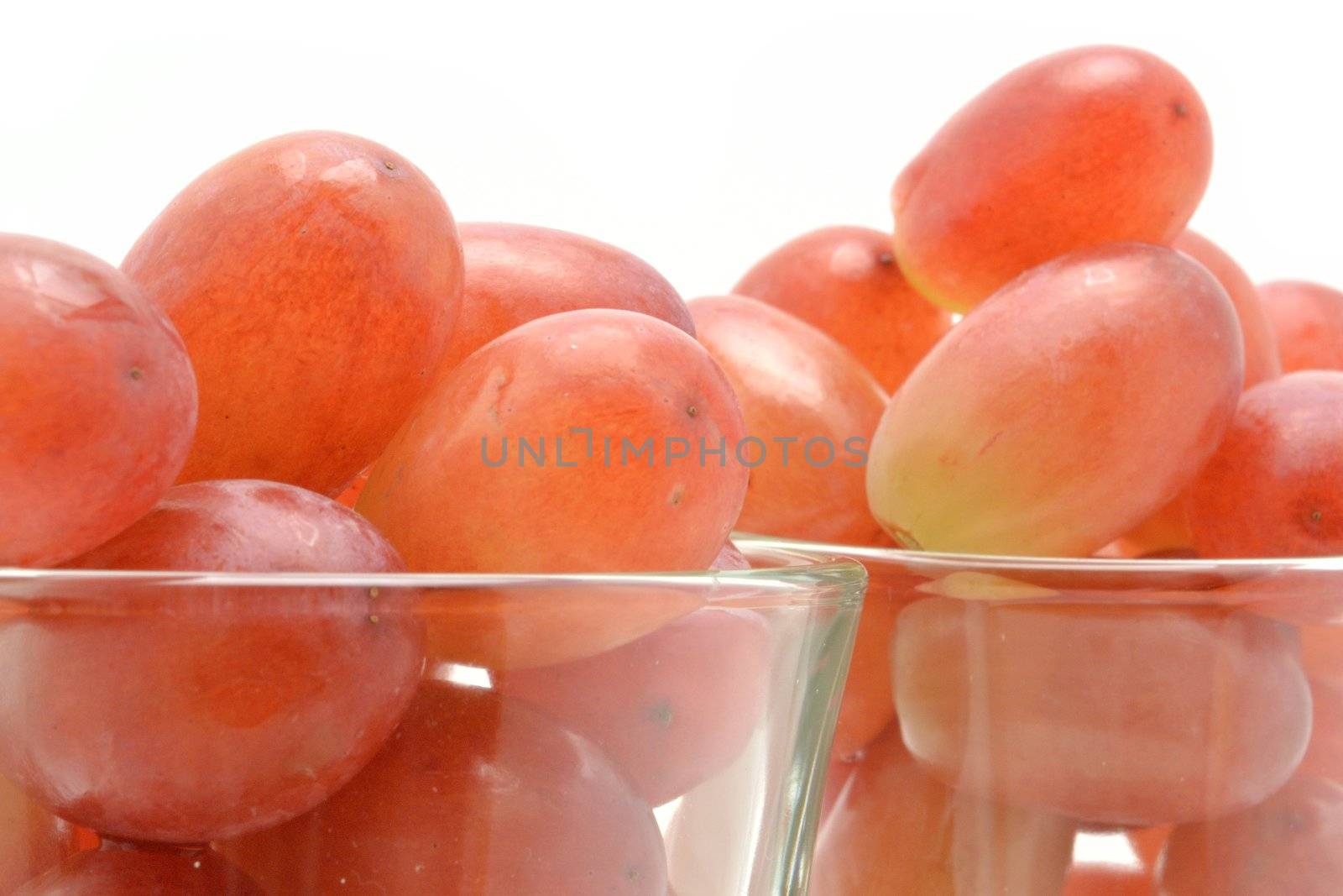 Red grapes in glasses over white background