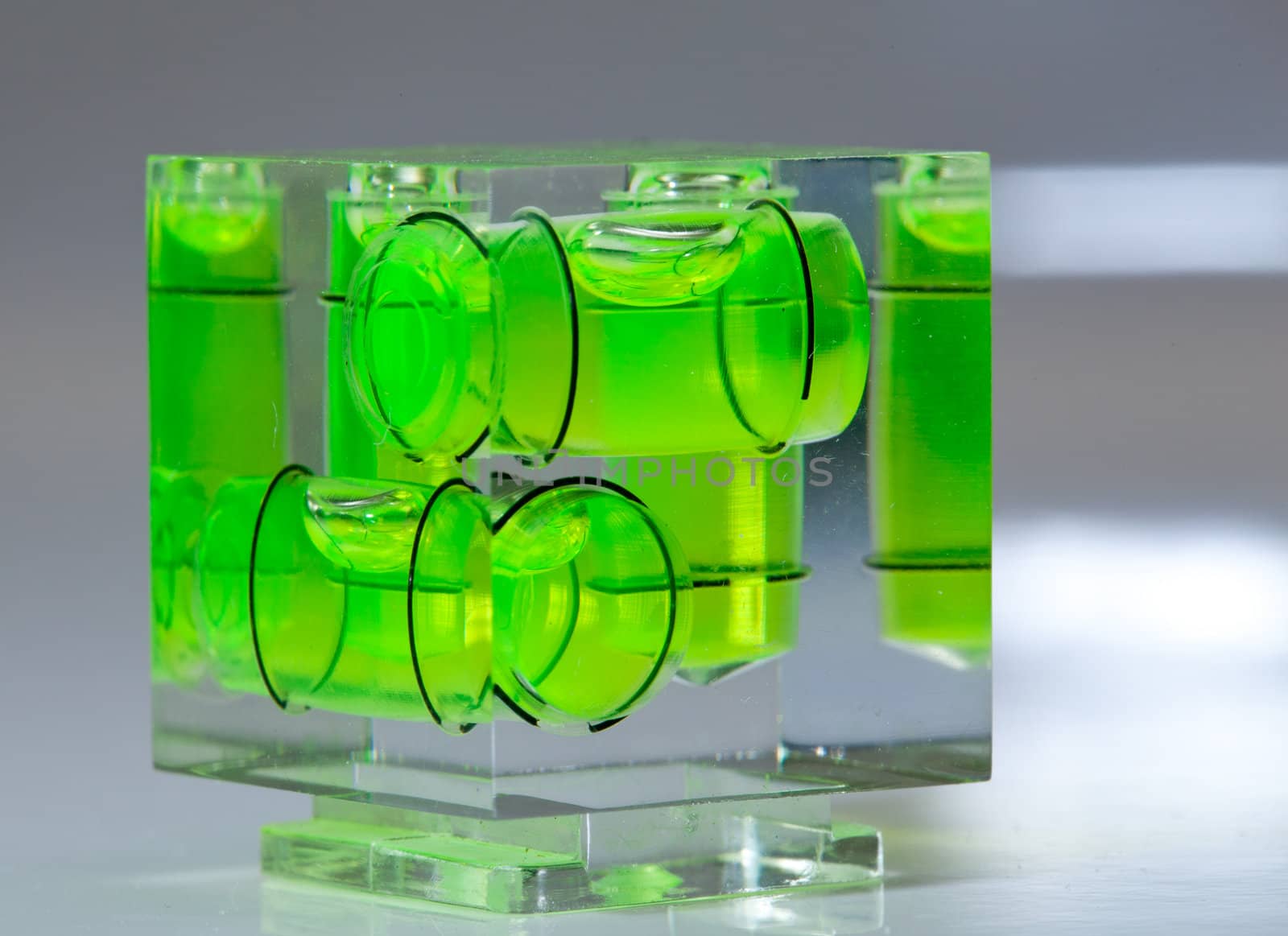 Three green spirit levels in plastic cube setting angle in any direction