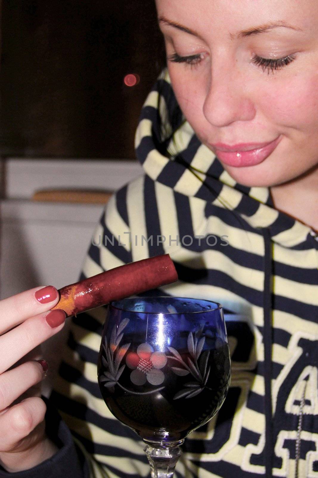 Woman with glass of mulled wine and cinnamon by Metanna