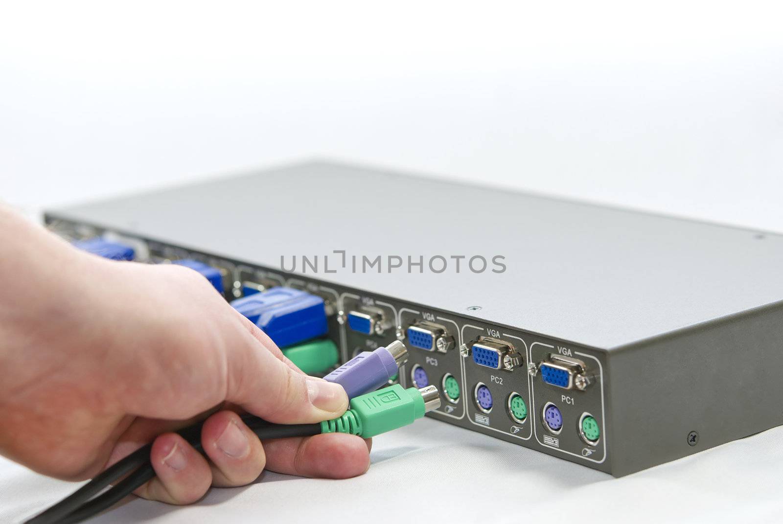 KVM (keyboard, video and mouse) switch and a human hand with network cables on white background