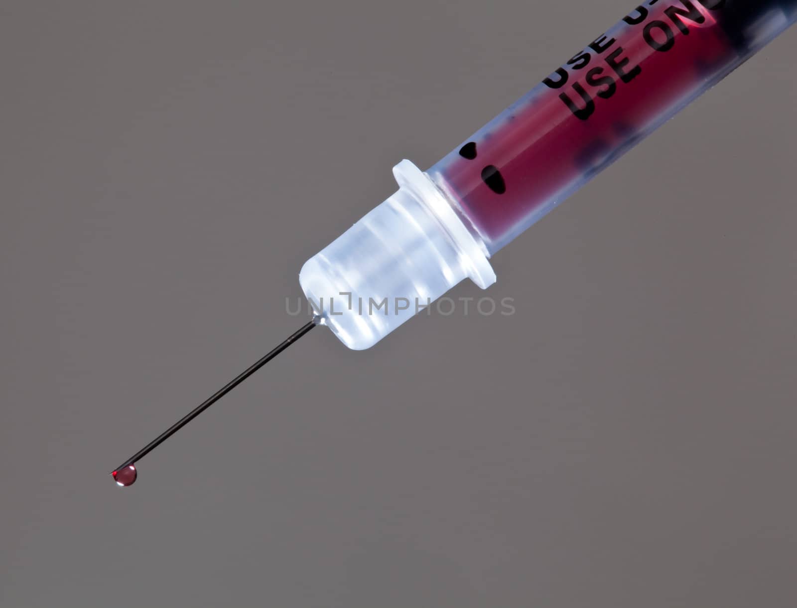 Macro of a drop of blood on the end of a hypodermic syringe needle