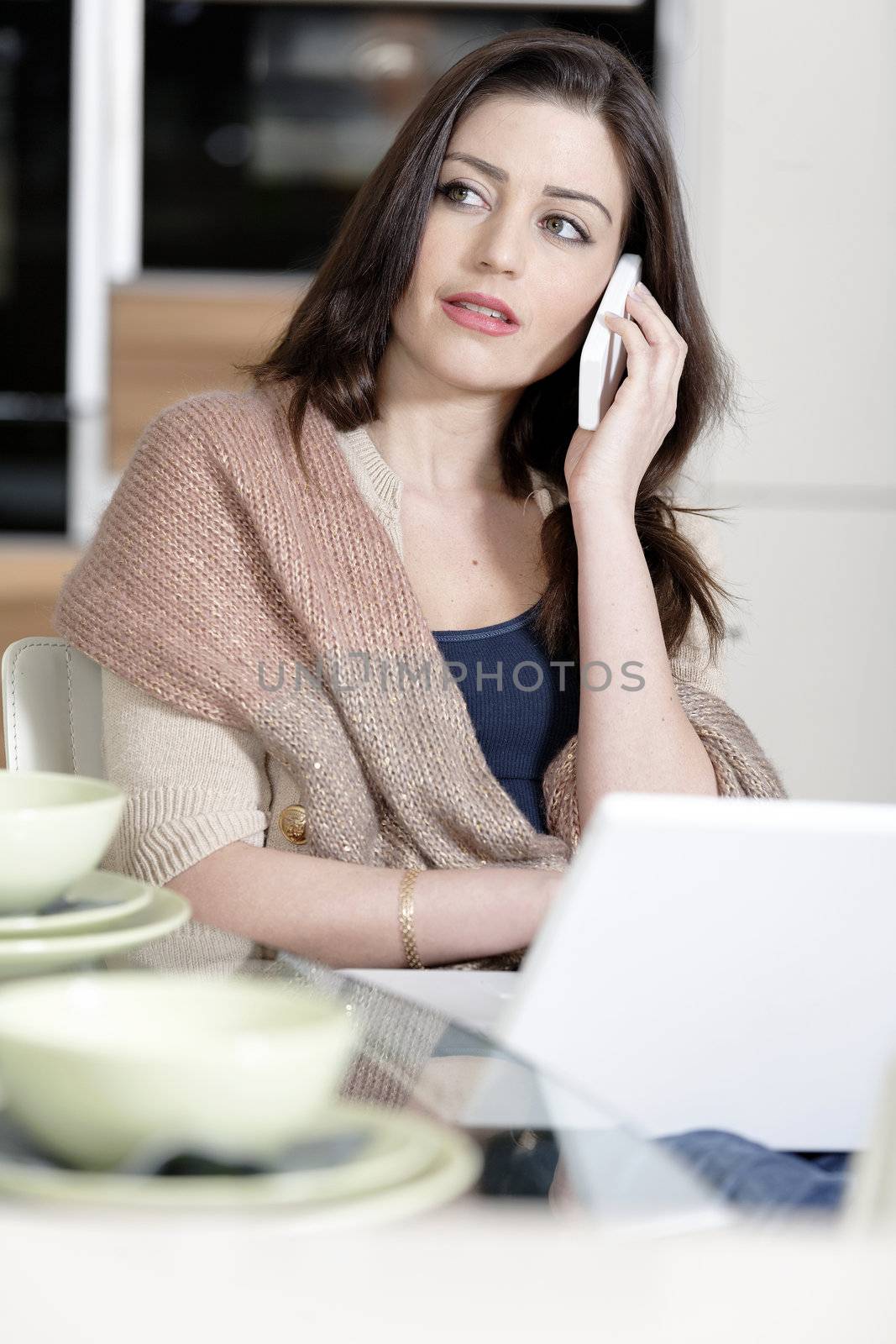 Woman using her laptop in kitchen by studiofi