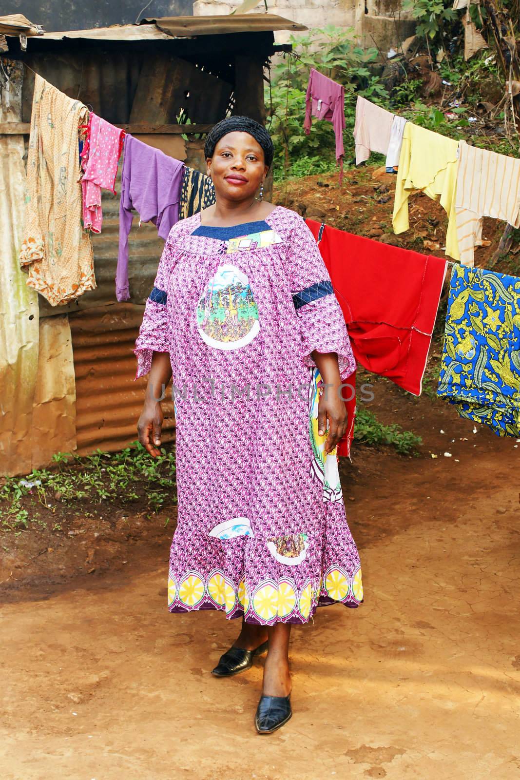 Pregnant black African woman in her backyard with clothesline.