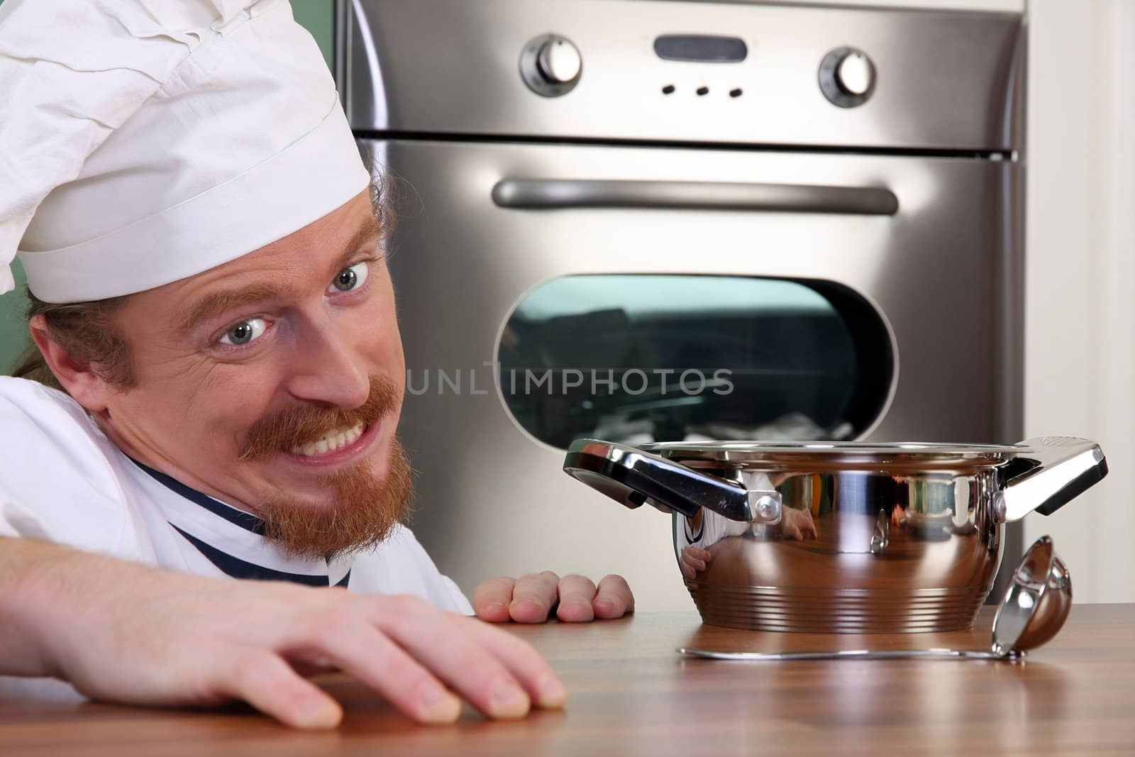 Funny young chef with a pot