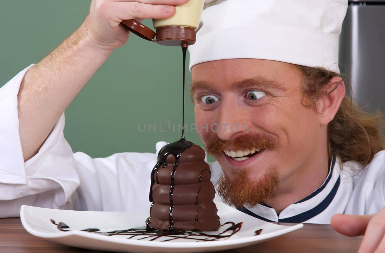 Funny young chef added chocolate sauce at piece of cake by vladacanon