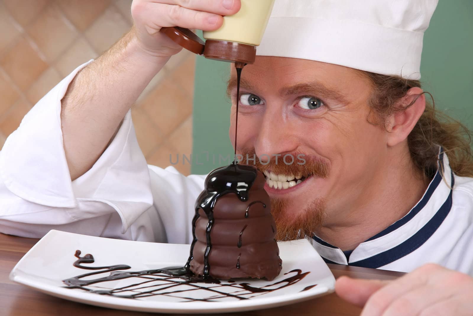 Funny young chef added chocolate sauce at piece of cake by vladacanon