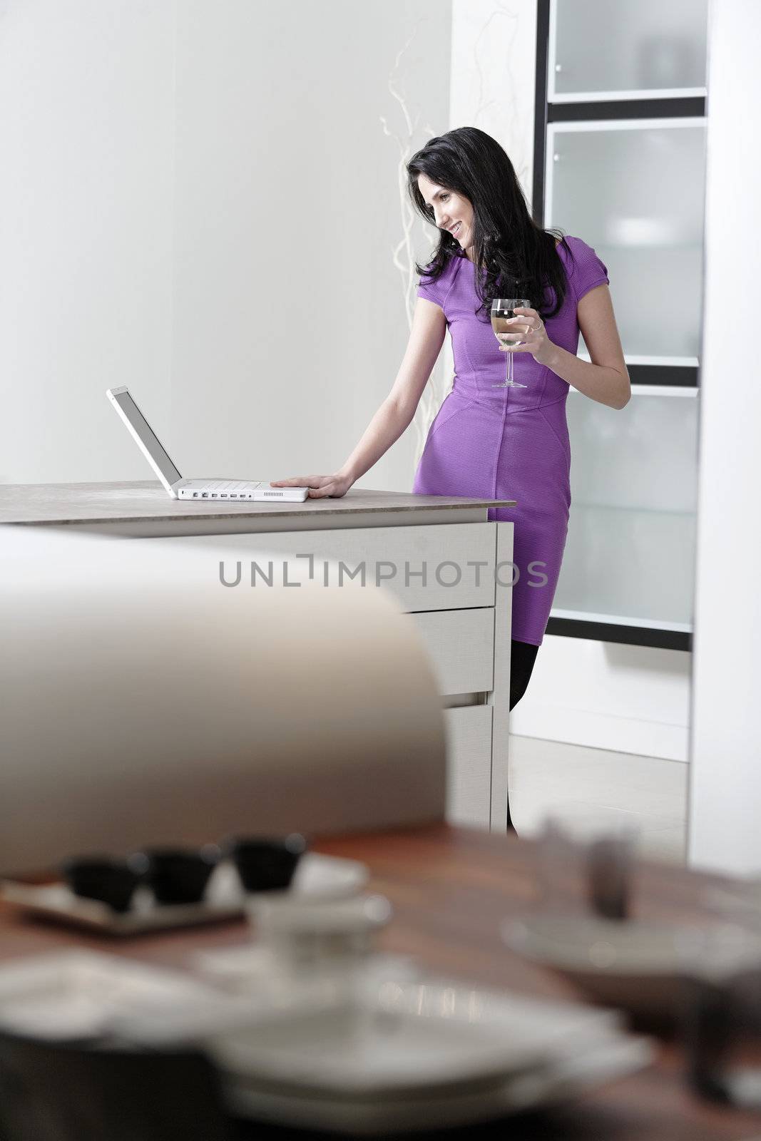 Attractive young woman in a dinner dress using a laptop.