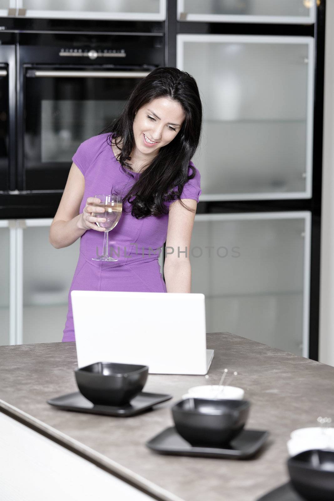 Attractive young woman in a dinner dress using a laptop.