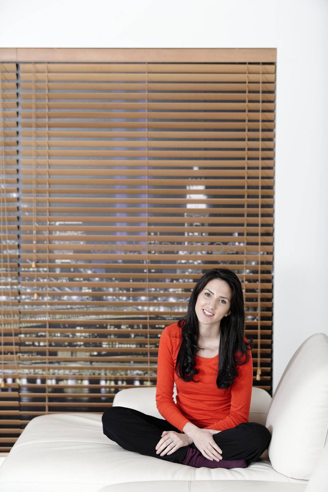 Beautiful woman relaxing on a white sofa in an elegant living room.