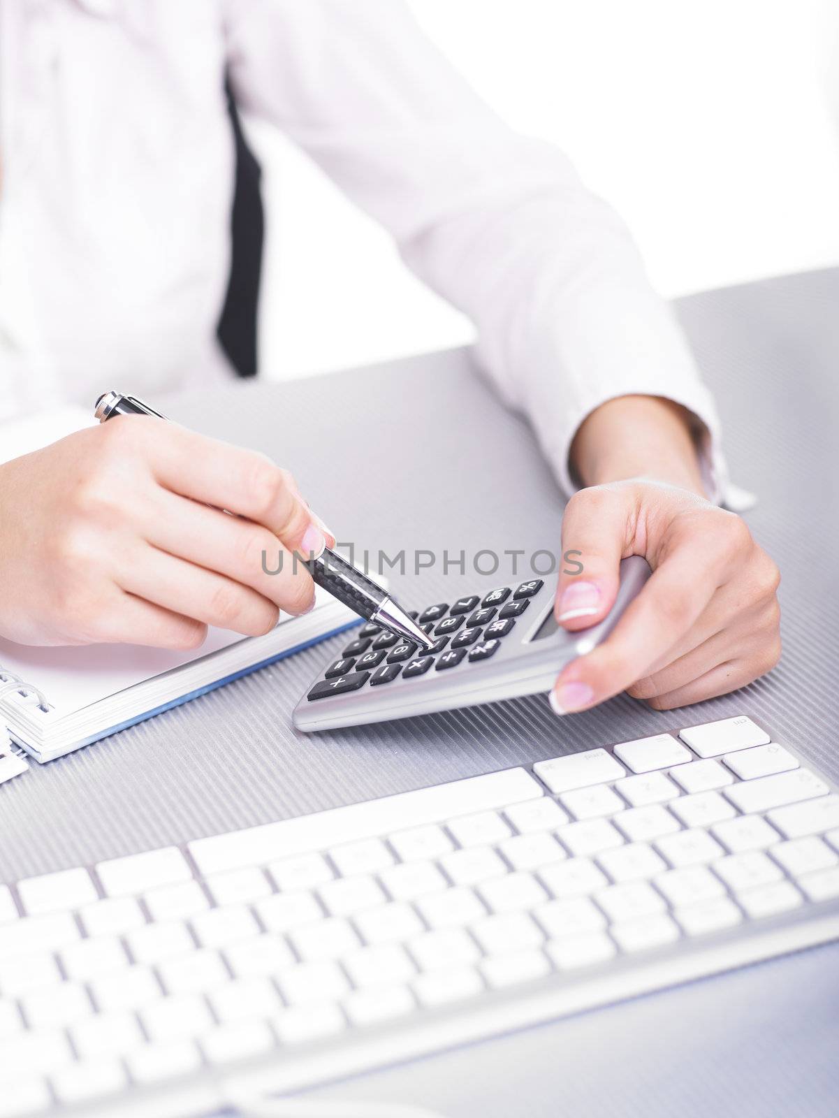 Bussines woman calculating with calculator in office