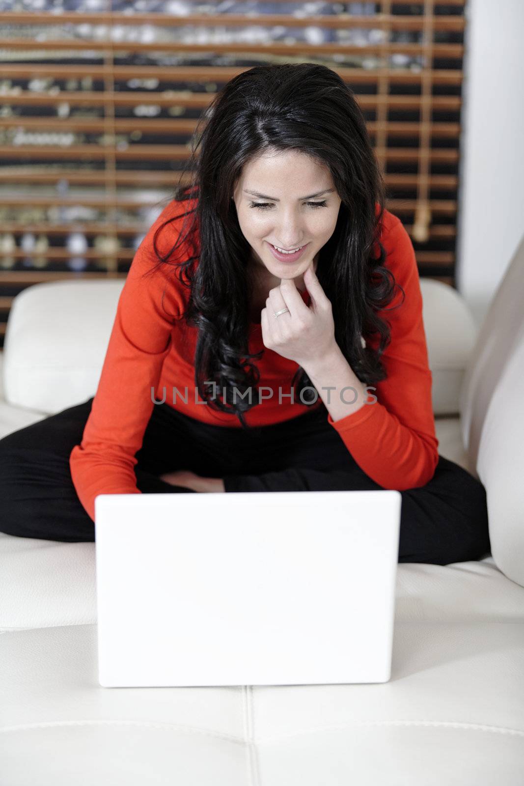 Attractive woman using her laptop in her living room.