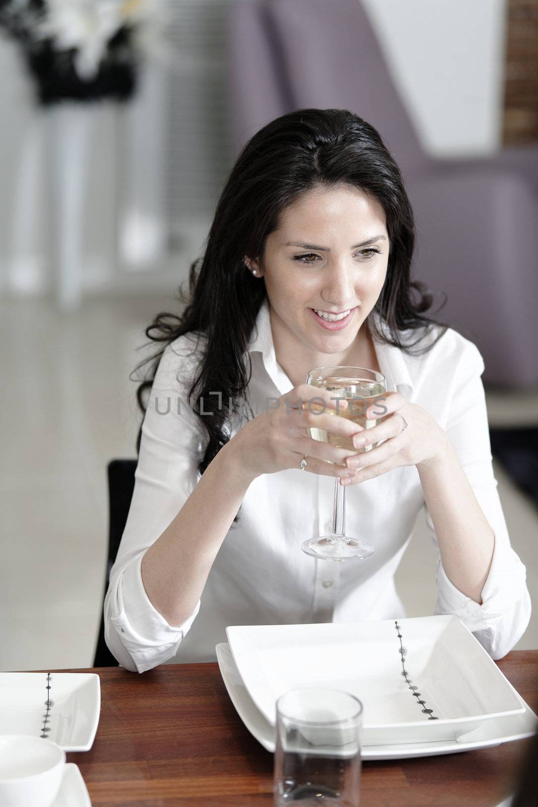 Attractive elegant woman enjoying a meal at the dinner table.