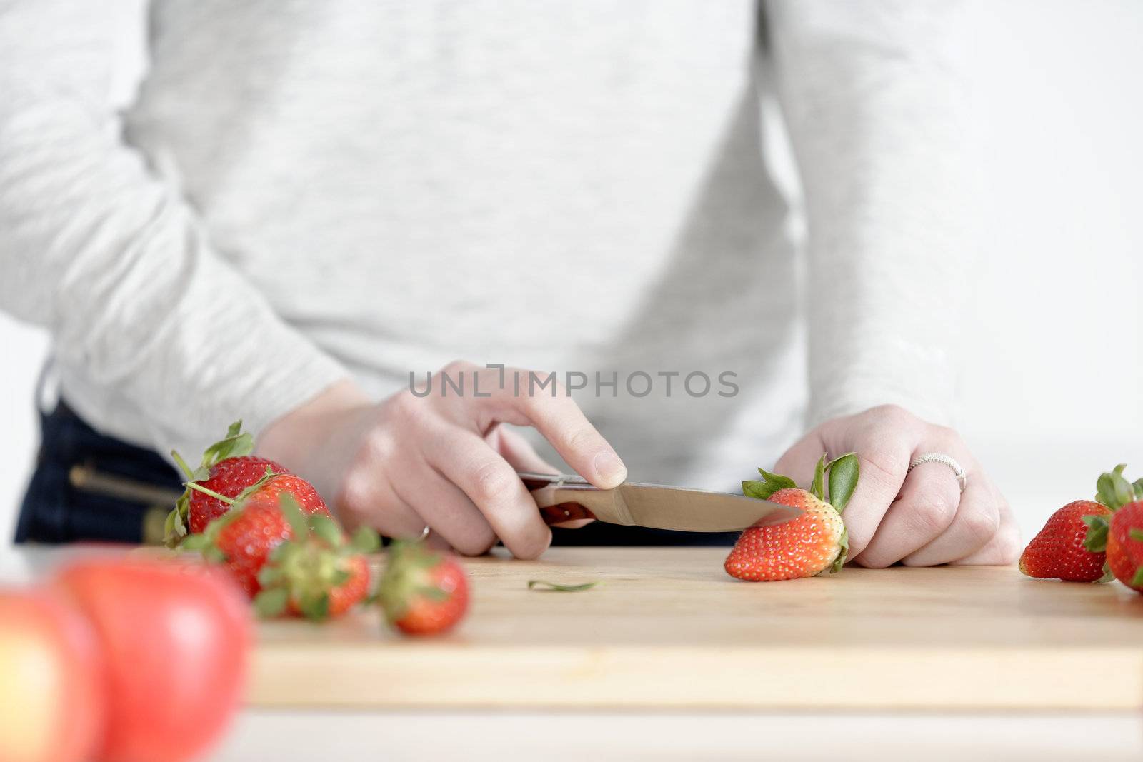 Woman cutting up fruit by studiofi