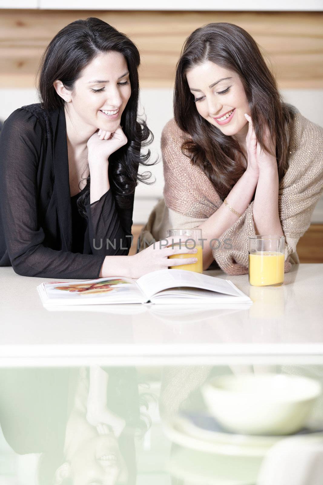 Two friends reading recipes by studiofi
