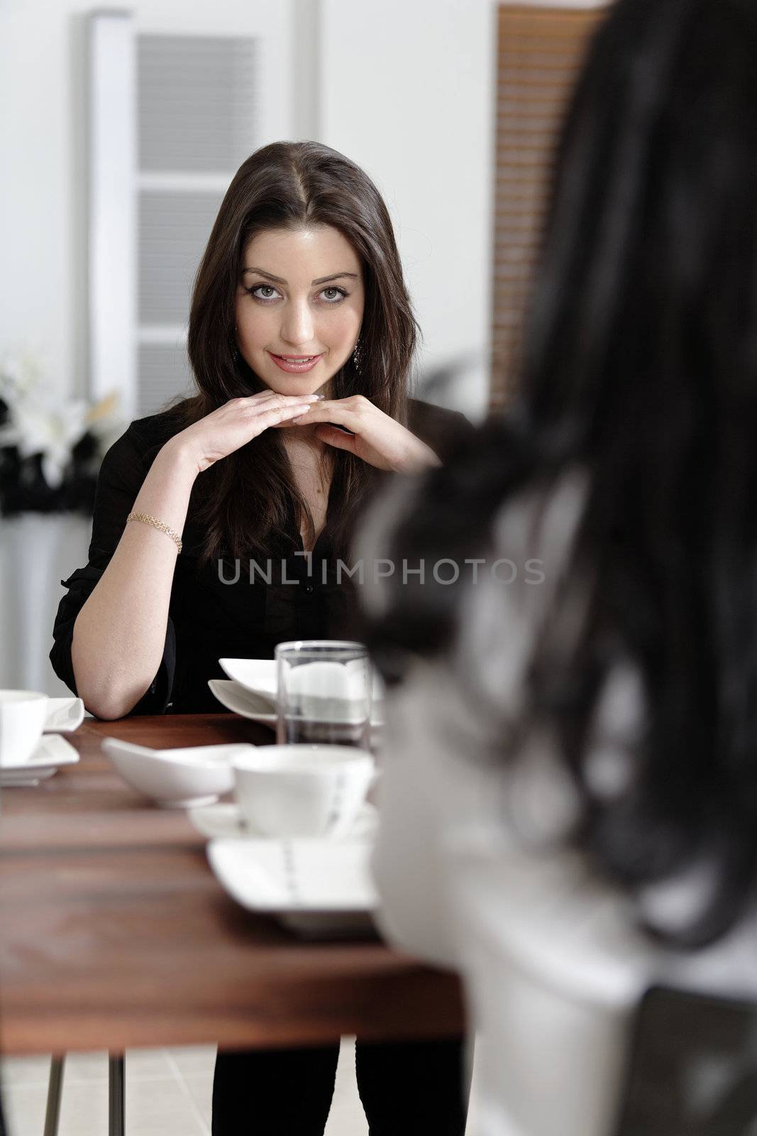 Two friends enjoying a meal by studiofi