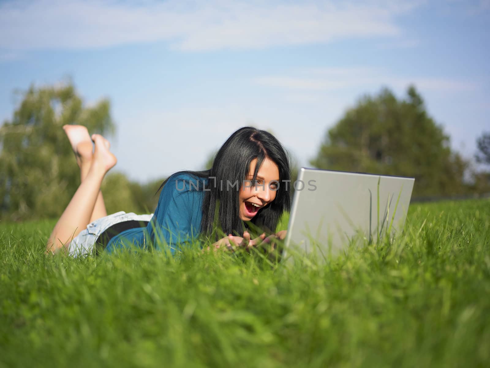 Young woman using laptop in park