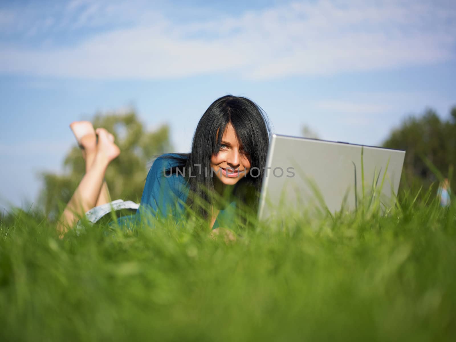 Young woman using laptop in park