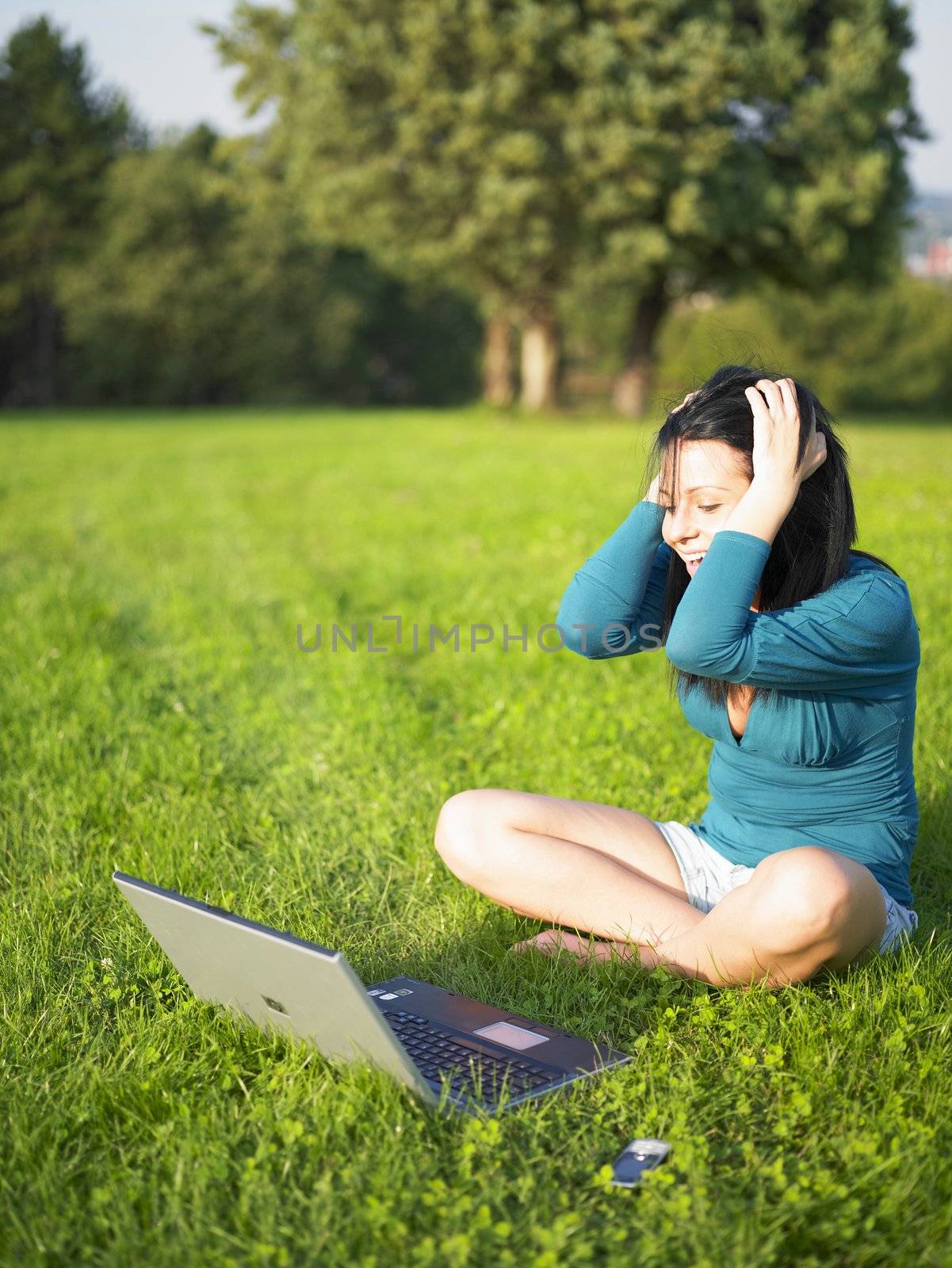 Woman with laptop in park by adamr